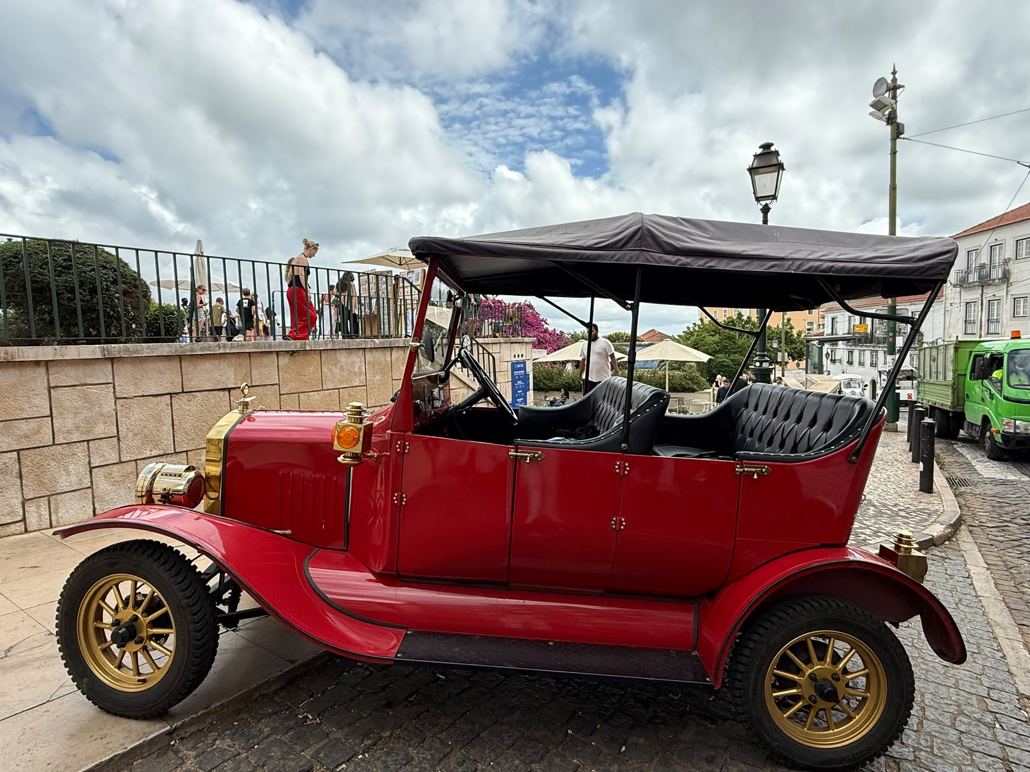 Red vintage touring car on a cobblestone Lisbon street